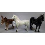 Three Beswick animal figures; a black Fell pony, a dapple grey Welsh Mountain pony and a donkey. (3)