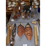 Two trays of carved tribal items: two elephant lamp stands, rhinoceros, lion, face masks etc. and