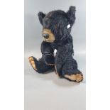 A vintage black Teddy Bear with composition nose and glass eyes, plastic pads. 43cm high approx. (