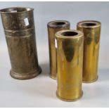 Three brass Second World War period shell case vases, together with an oxidised metal cylinder vase.