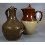 Two stoneware jugs or pitchers; one lidded two tone tea or coffee jug and a wine jar with stopper