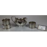 Collection of assorted silver items, to include: three napkin rings and a cream jug. 4.3 toy ozs