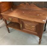 Edwardian mahogany side table, having gallery top above ornately carved door on turned supports. (