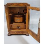 Early 20th century oak smoker's cabinet with fitted interior, wooden tobacco jar and glazed door.