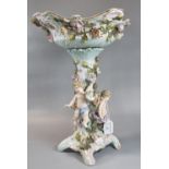 A Sitzendorf German porcelain table centre piece with floral decoration and cherub mounts. Hatched