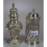 Two silver pepperettes with repousse wrythen decoration. Both with London hallmarks. (B.P. 21% +