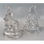 Pair of hollow clear moulded glass figures: 'Punch and Judy', on circular step bases with moulded