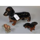 Two Beswick dachshunds together with another recumbent dachshund. (3) (B.P. 21% + VAT)
