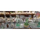 Three trays of assorted glassware: novelty bottles in the shape of a fish, a male torso, skull, hand