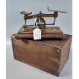 Set of brass letter scales with graduated brass weights on a moulded wooden base with appearing