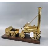 Modern brass model of the steam locomotive Stephenson's Rocket, on wooden plinth. 33cm long