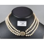 Triple row of cultured pearls with 9ct gold pearl set clasp. Length 16 inches. (B.P. 21% + VAT)