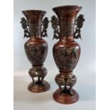 Matching pair of Oriental bronze baluster vases on integral tripod stands with phoenix handles and