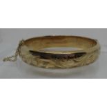 Hinged bangle engraved with scrolling foliage in 9ct gold. Approx weight 16.8 grams. (B.P. 21% +