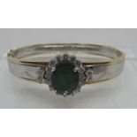 Emerald and diamond hinged bangle set in yellow and white 18ct gold. The treated emerald approx
