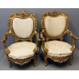 Pair of French style Rococo giltwood open arm salon chairs on large circular stuff over seats