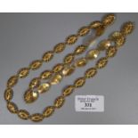 Indian gold dowry chain with decorative faceted oval links decorated with red and green enamel.