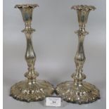Pair of mid Victorian silver candlesticks, having shaped circular loaded bases with shell