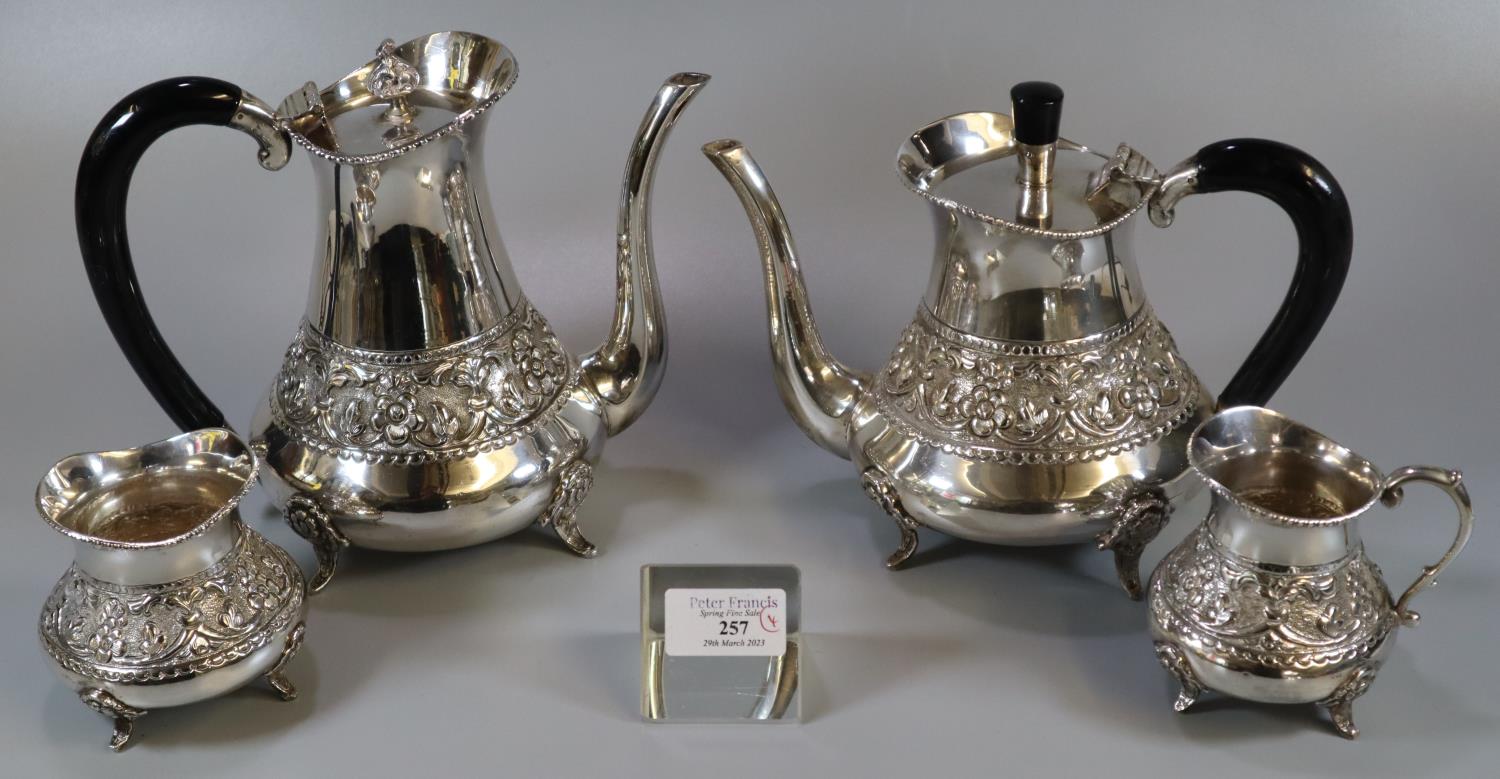 Indian white metal four piece tea service comprising teapot and water jug with ebonised handles,