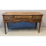 18th century oak dresser base, the moulded top above an arrangement of three drawers with brass swan