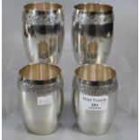 Set of four Indian silver barrel shaped beakers/tumblers with engraved floral and foliate