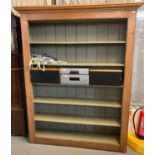 rustic pine painted bookcase of large proportions, the moulded cornice above boarded back with an