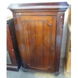 19th century mahogany blind panelled corner cupboard, now on bun feet with low gallery back,