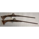 Pair of rustically made Arab style flint lock muzzle loading wall piece guns with studded wooden