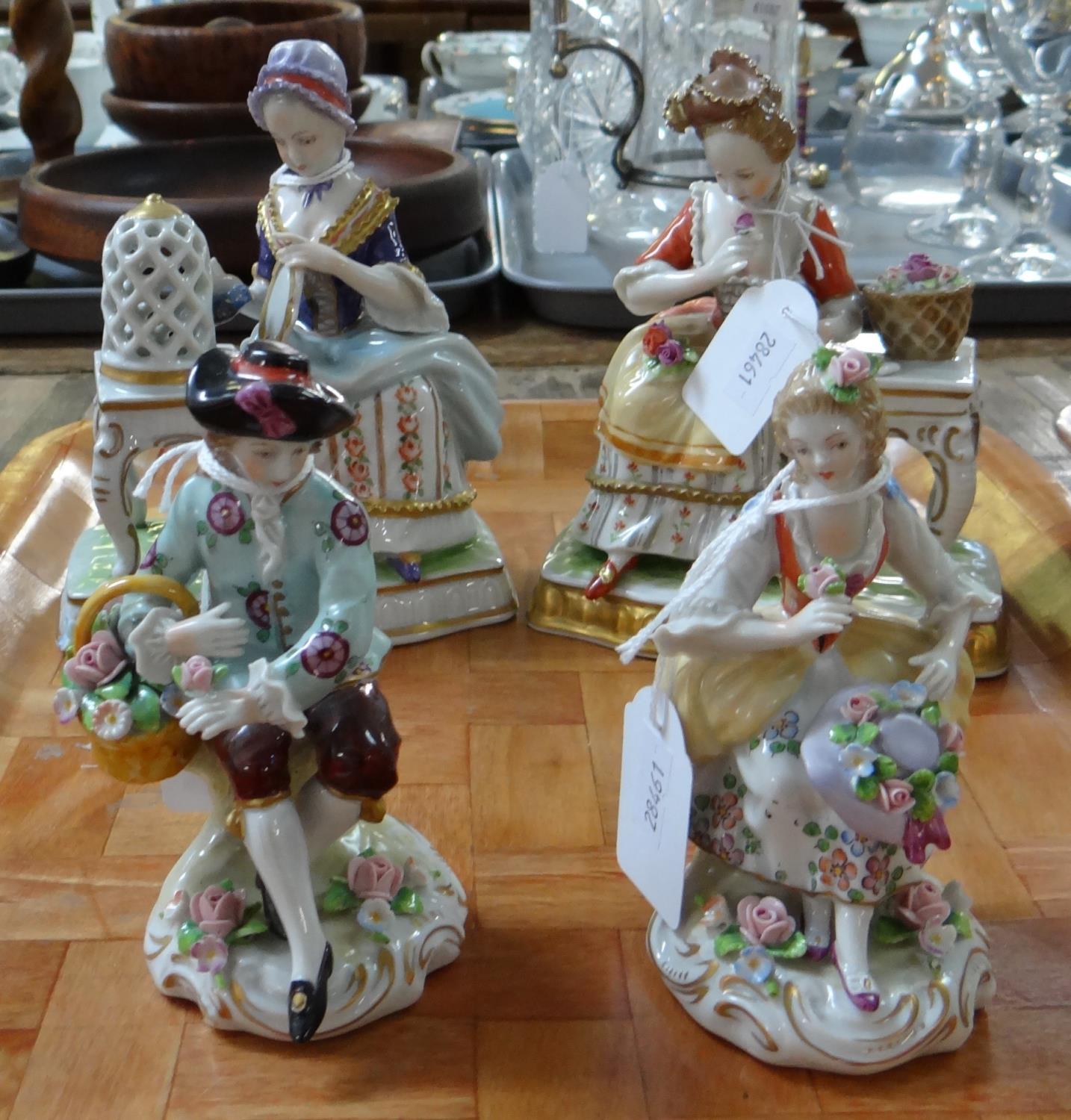 Pair of continental porcelain figurines of a man and woman in 18th century dress with basket of