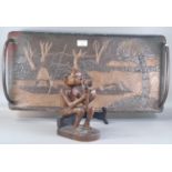 Carved wooden tribal figure in seated pose. Together with a Zambia metals art two handled tray. (