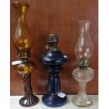 Three early 20th Century single oil burner lamps, varying glass colours. (3) (B.P. 21% + VAT)