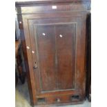 Early 19th oak hanging corner cupboard with blind panelled door revealing shaped shelves to the
