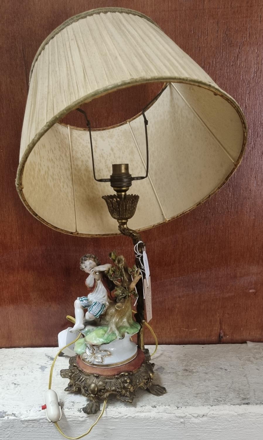 Continental porcelain table lamp in the form of a young musician on a naturalistic and gilt metal