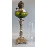 Early 20th century single burner oil lamp having green glass reservoir standing on a white metal WMF