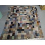 Antique handmade woollen patchwork quilt with plain purple backing, swirled sewn in decoration.