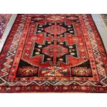 20th century Middle Eastern design red ground carpet with central medallion design, stylised birds