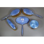 A silver and guilloche enamelled dressing table set comprising: three brushes, hand mirror and a