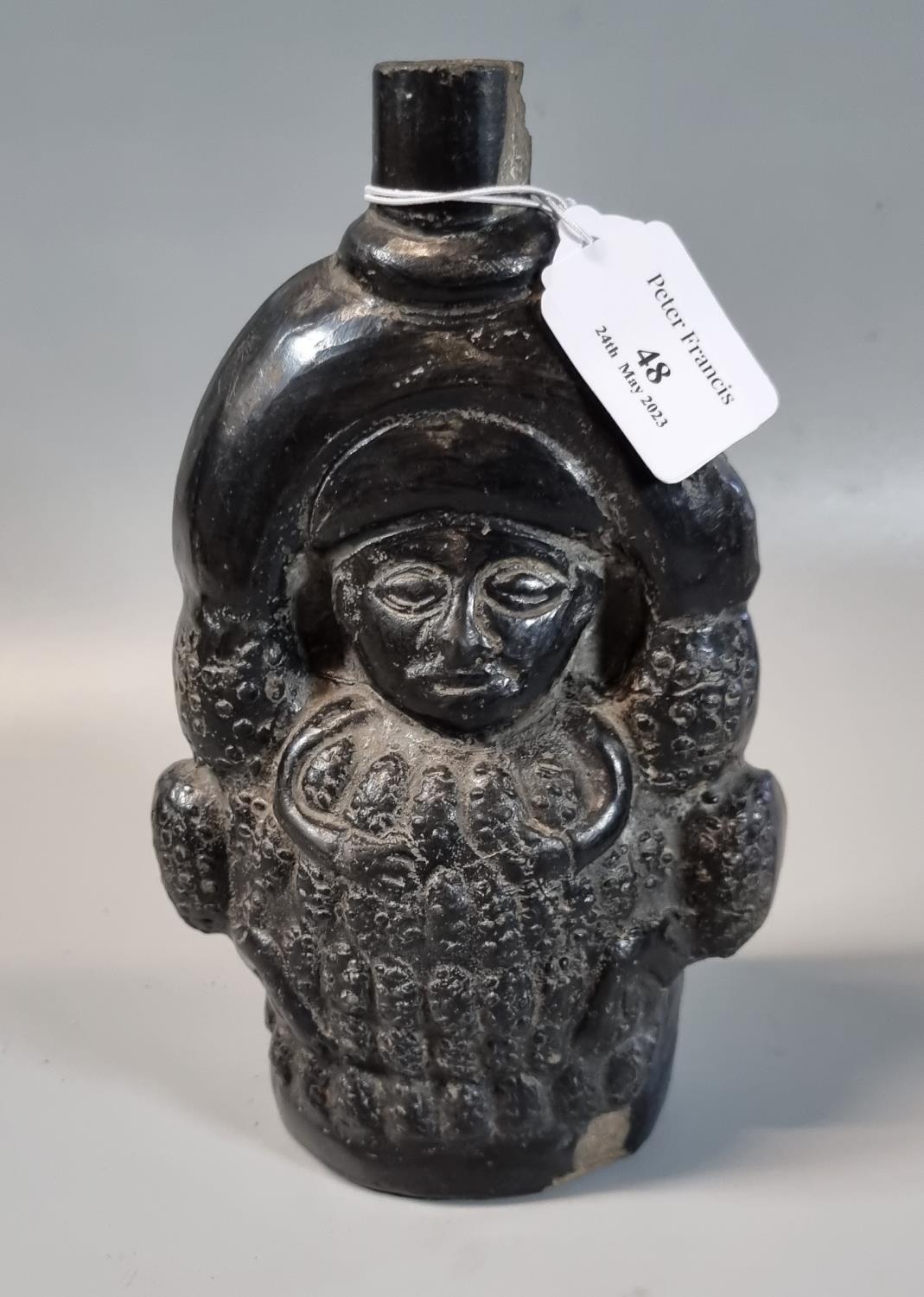 Medieval style black glazed moulded figural bottle. 20cm high approx. (B.P. 21% + VAT)