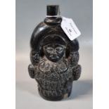 Medieval style black glazed moulded figural bottle. 20cm high approx. (B.P. 21% + VAT)