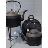 Two similar 19th century cast iron Kettles together with a stand and baking flat. (4) (B.P. 21% +