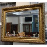 Good quality gilt framed bevel plate mirror overall decorate with relief flowers and foliage.