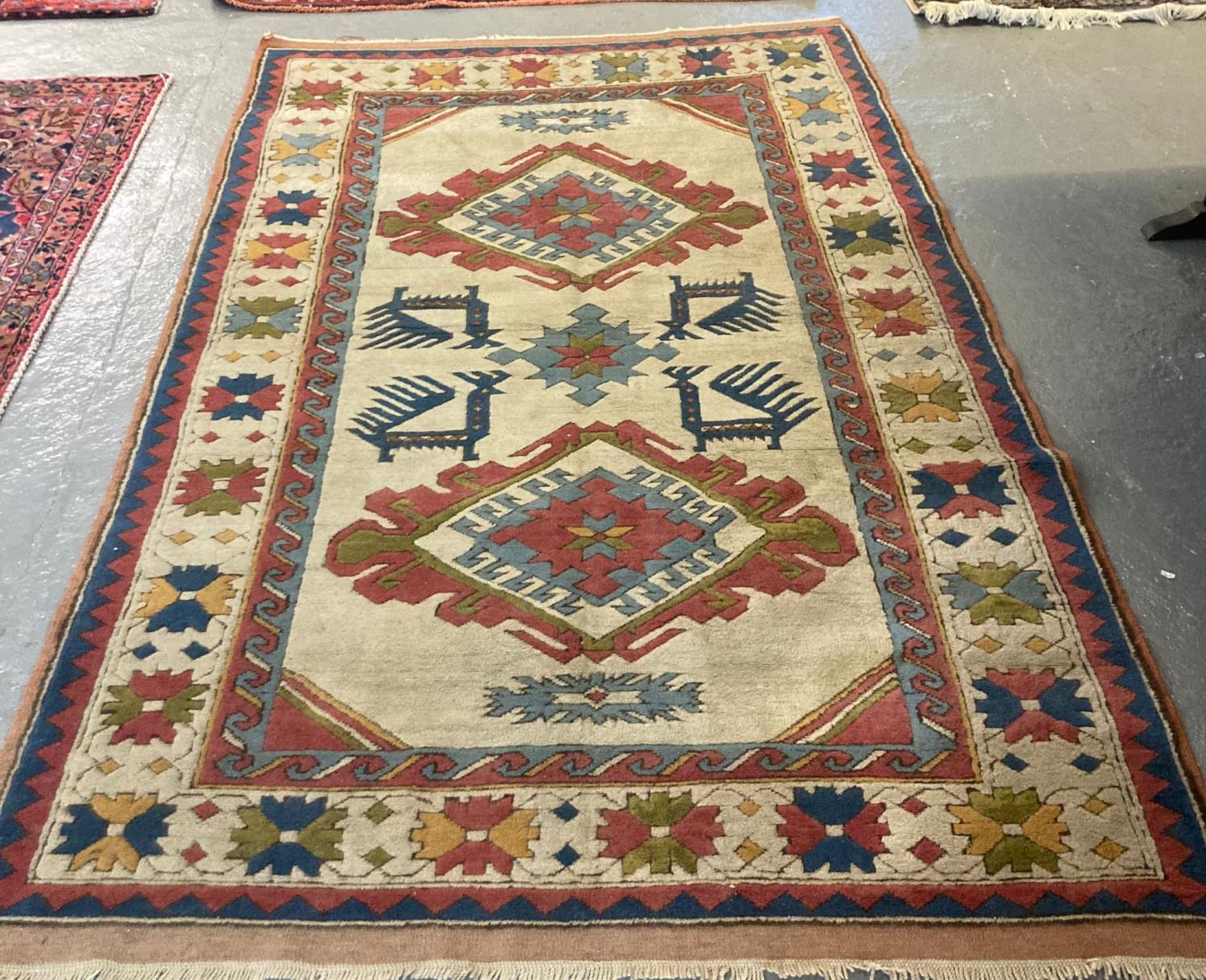 20th century Turkish multi-coloured beige ground carpet decorated with three lozenge medallions to