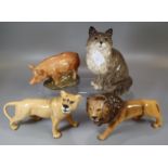 Four ceramic animal figures; A Beswick lioness and male lion, a Quail pig money box and a Beswick