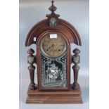 Early 20th century walnut architectural mantle clock with mask head mounts, pendulum and two