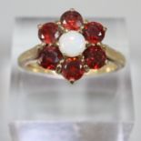 9ct gold red stone and opal flower head dress ring. Size N1/2. 6.7g approx. (B.P. 21% + VAT)