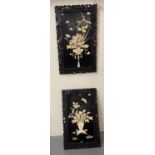 Pair of Japanese bone relief panels depicting flowers in vases within ebonised pierced frames. 87