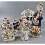 A collection of 19th Century Staffordshire flat back figurines and figure group spill vases;