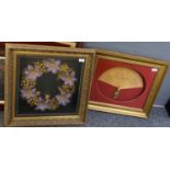 A framed decorative fan and a framed floral wreath. (2) (B.P. 21% + VAT)