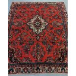 Red ground Persian Saruk village carpet overall with central floral medallion and decorated with