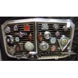 Post war Vauxhall motorcar radiator grill mounted with a varied collection of Vauxhall car badges,